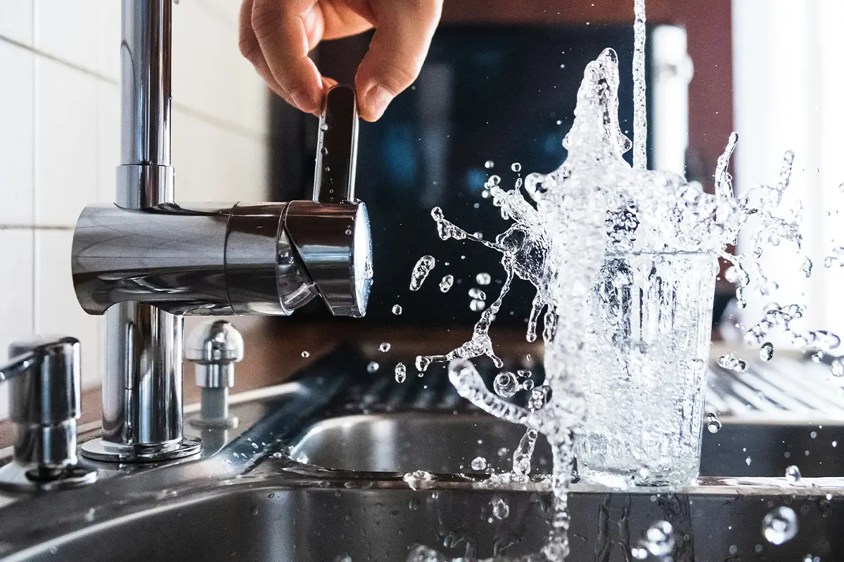 cup being filled with water in sink